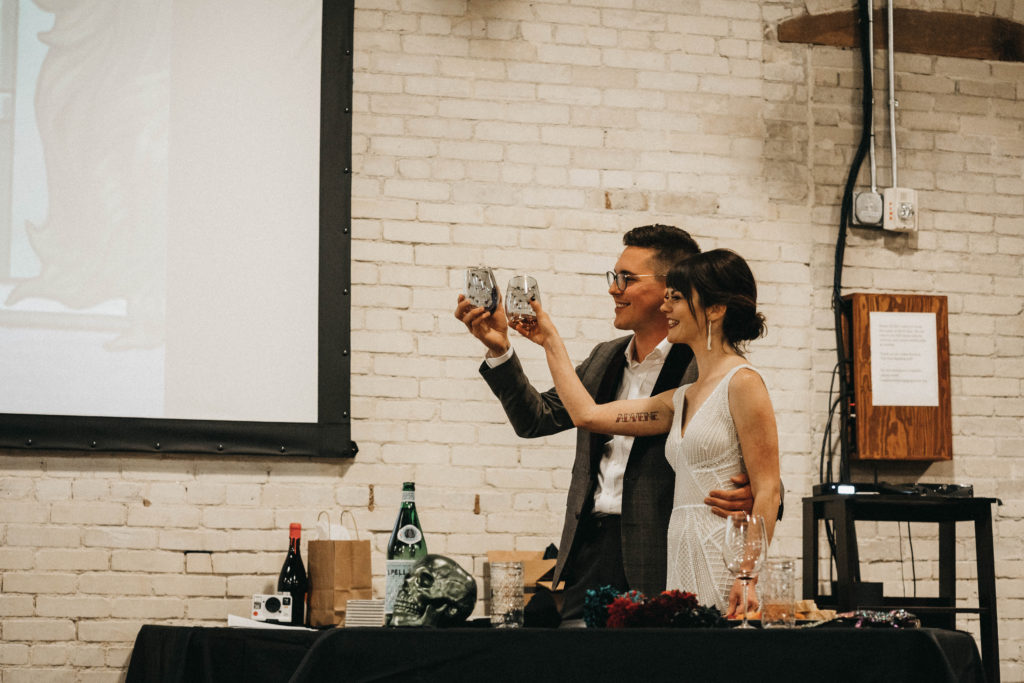 couple toasts to their friends during their anniversary party at the linen building