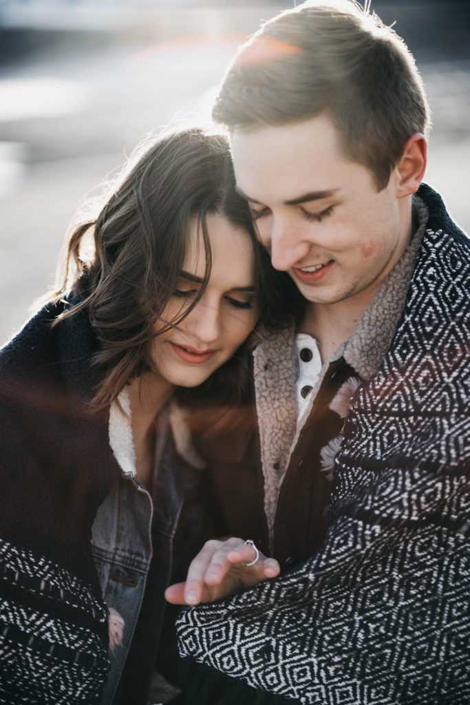 couple cuddles in a blanket to keep warm in the snow during their Idaho elopement