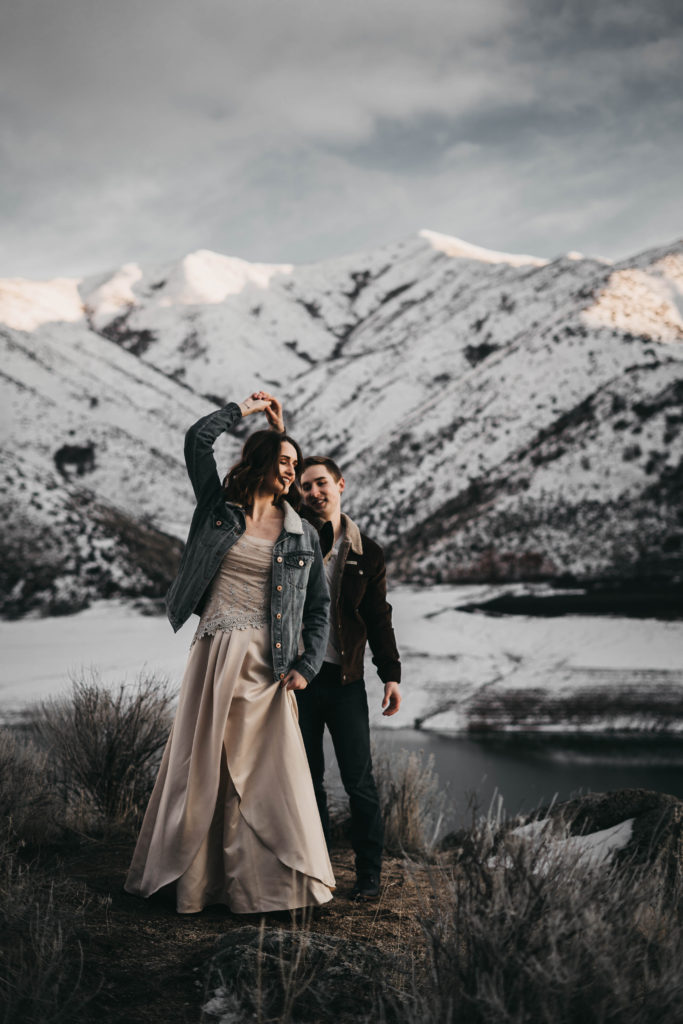 couple has their first wedding dance on the mountains surrounding lucky peak lake