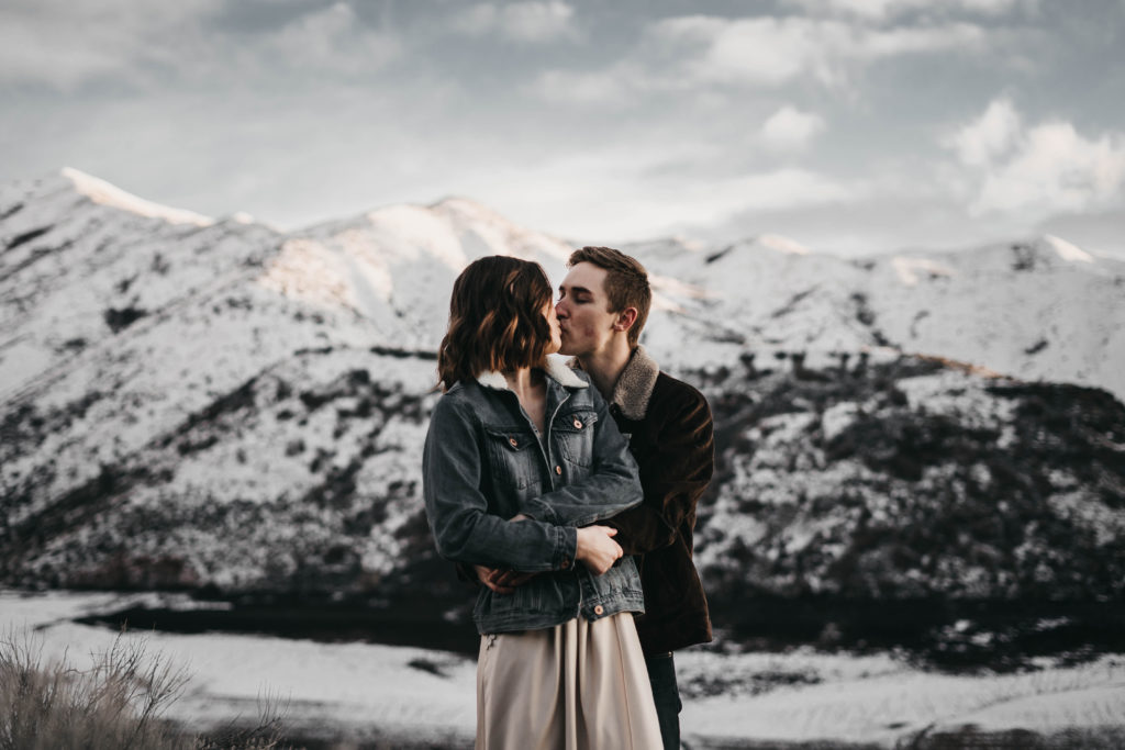 Lucky Peak Lake elopement couple kisses on a snowy mountain