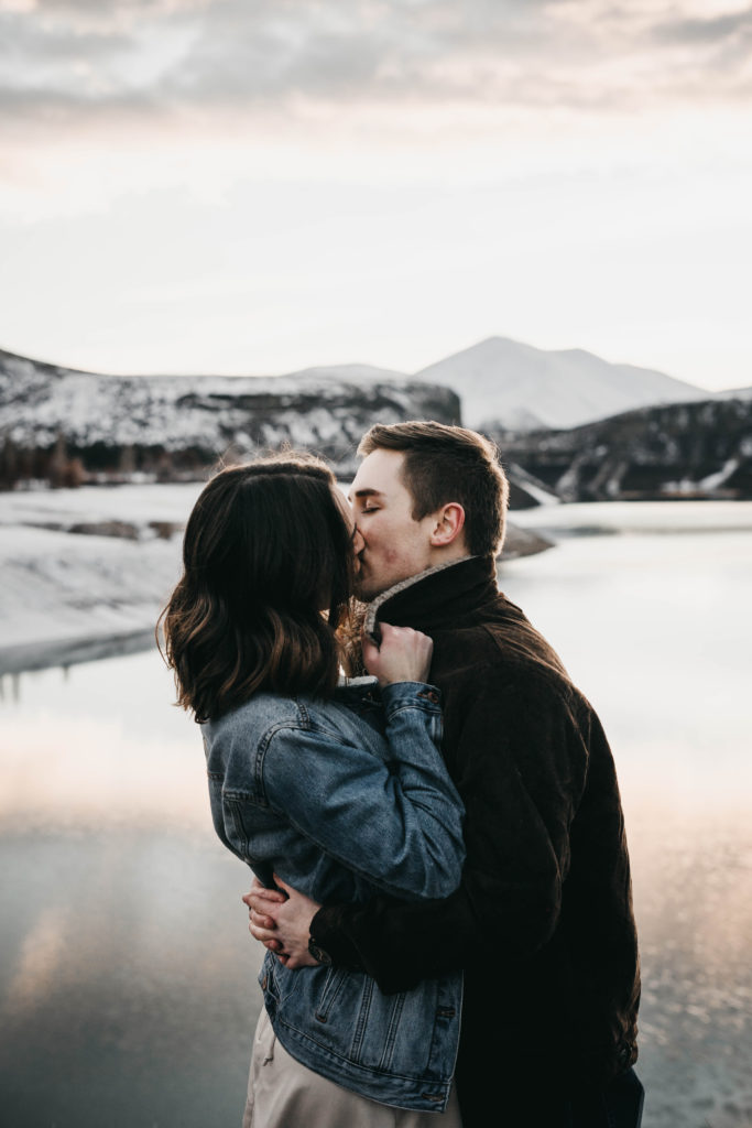 couple kisses in front of lucky peak lake at sunset during their elopement
