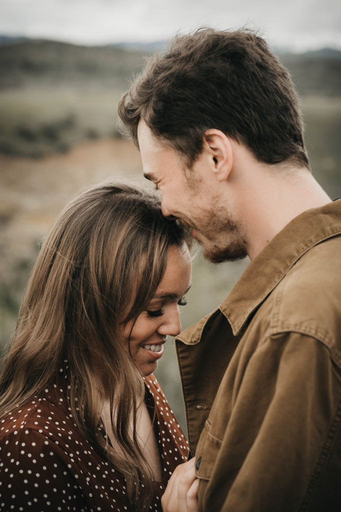 couple laugh together during their boise foothills engagement session