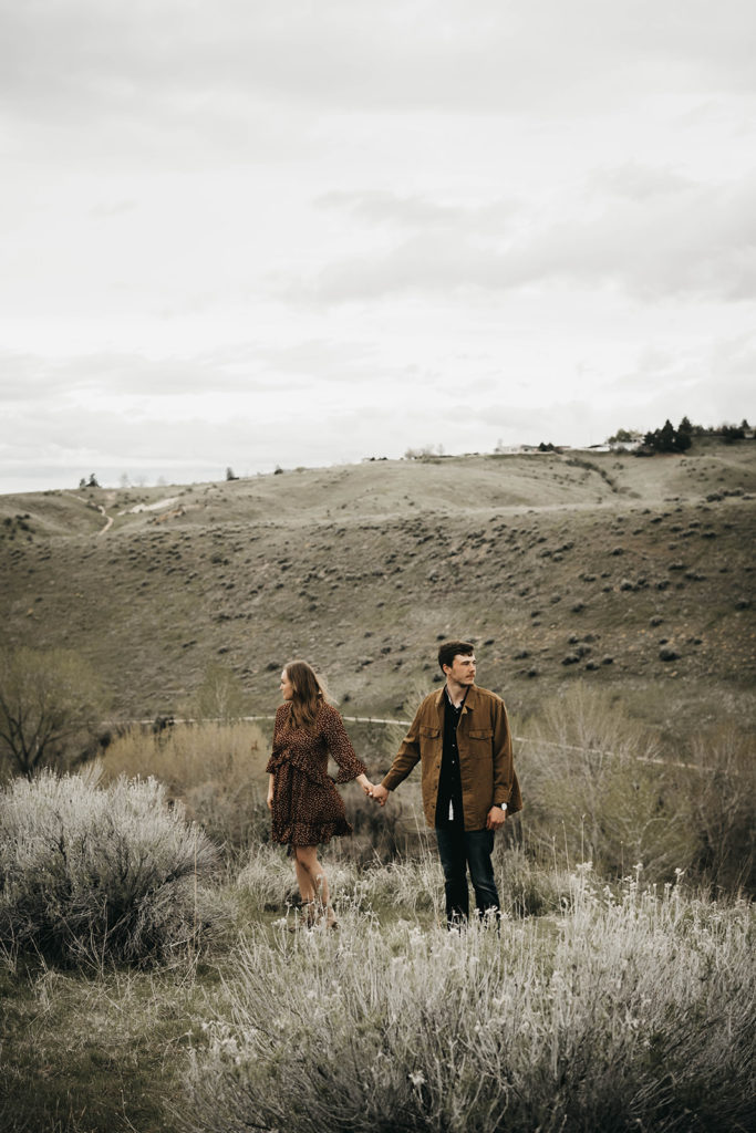 couple stands together in the boise foothills during their engagement session