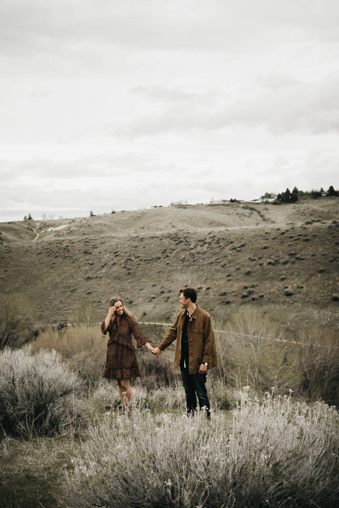 couple holds hands in the boise foothills