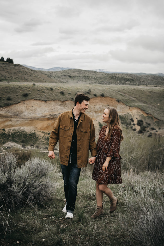 couple holds hands and laughs together during their boise engagement session