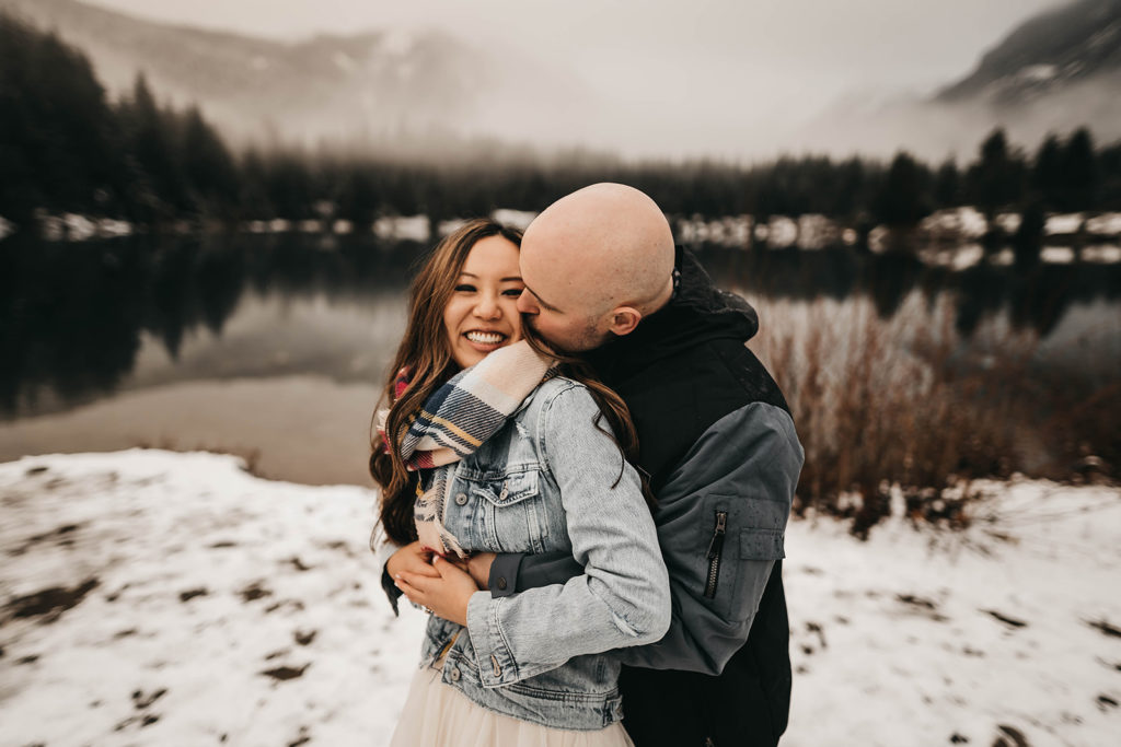 photo of a couple in the snow at gold creek pond during a snoqualmie pass engagement session