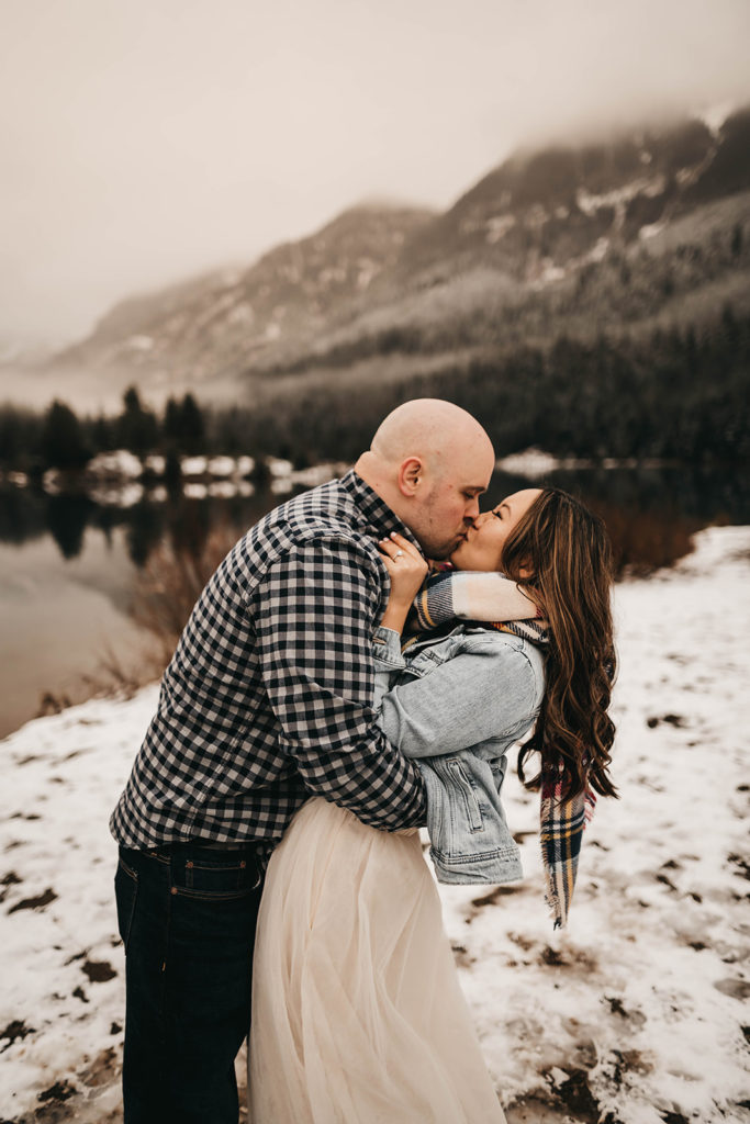 couple kisses in the snow at gold creek pond