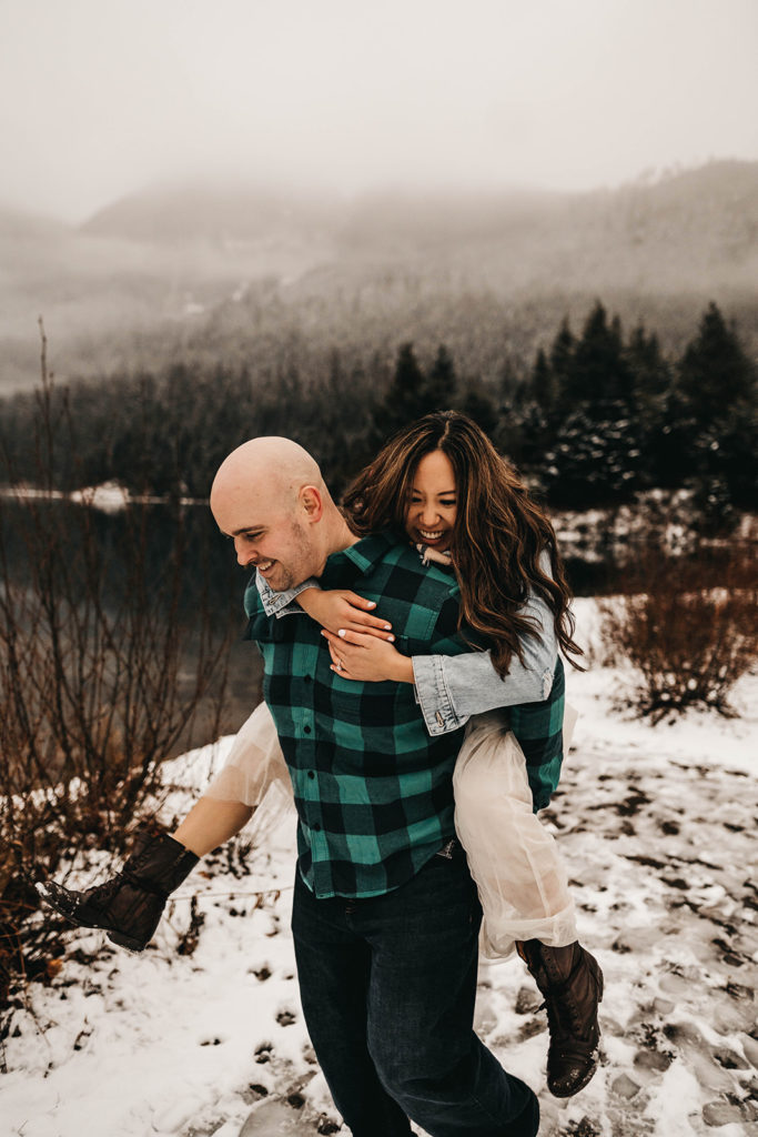 couple plays in the snow at snoqualmie pass during their engagement session