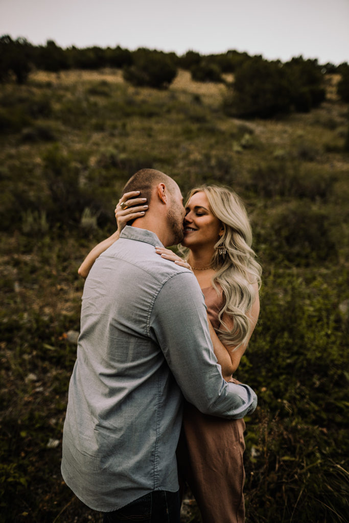couple cuddles close together during their engagement session outside of idaho falls