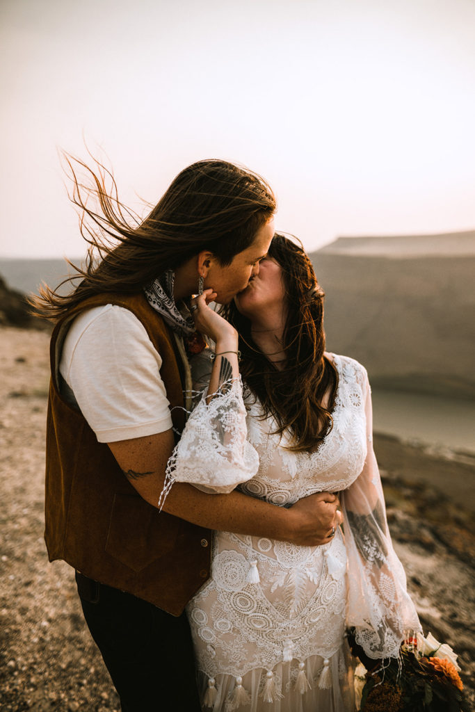 Couple embraces and kisses for portraits after their elopement ceremony