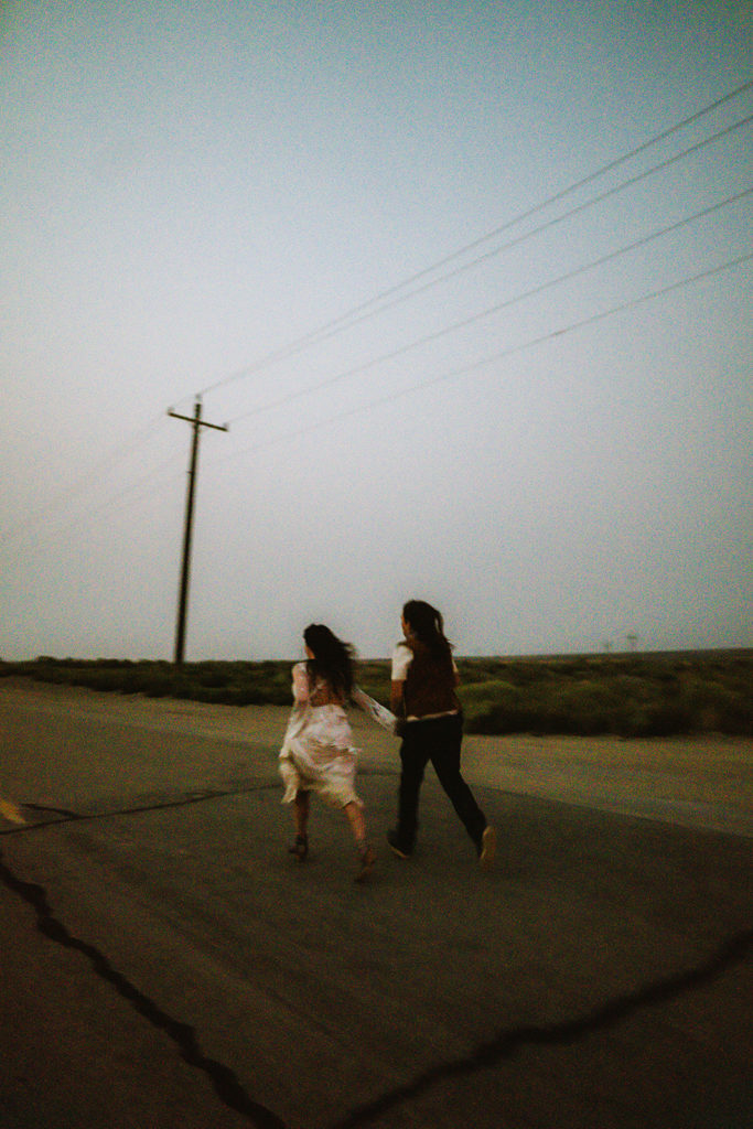 dusk photos of couple running on desert road