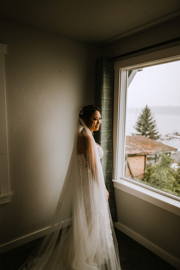 Bride waits anxiously in front of the window for their first look