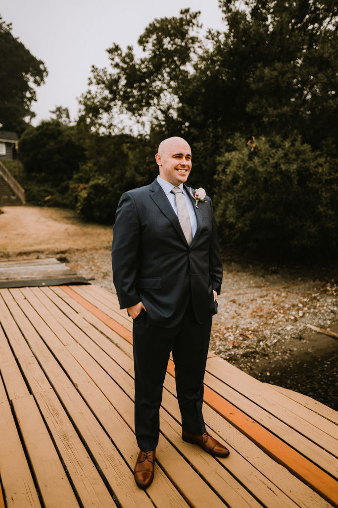 groom waits on the dock for the first look with his bride