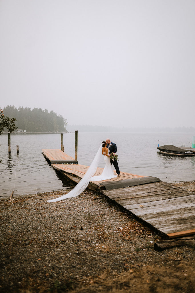 bride and groom share a kiss on the dock during their first look