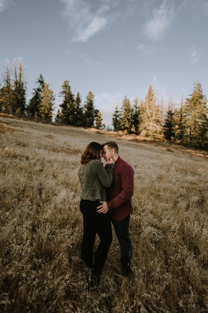 couple stands in a mountain field together during their couple's session