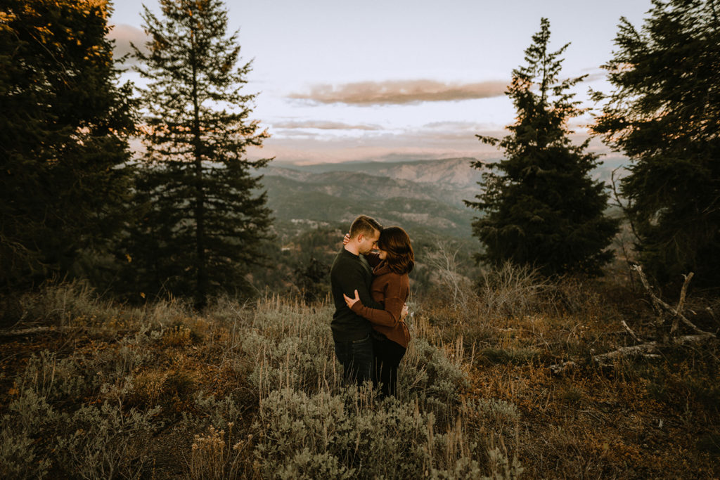 couple holds each other close with gorgeous Idaho mountain view during their Bogus Basin couple session