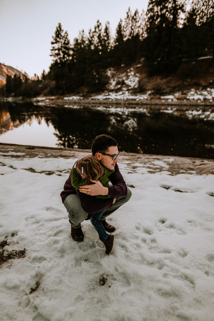 father hugs his daughter with the Payette River in the background