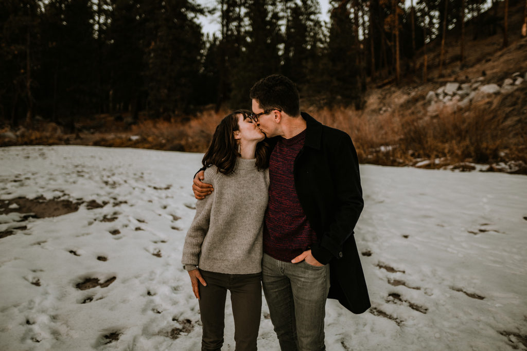 couple kisses each other during their Payette River family session
