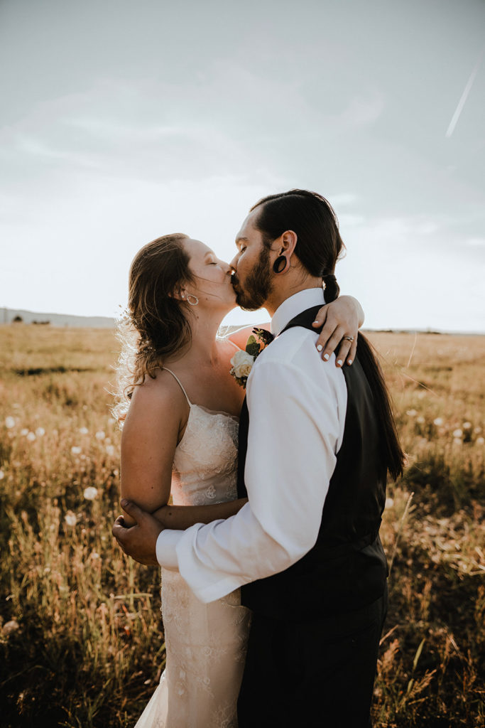 Bride and Groom kissing in a field, during sunset photos at their intimate donnelly wedding