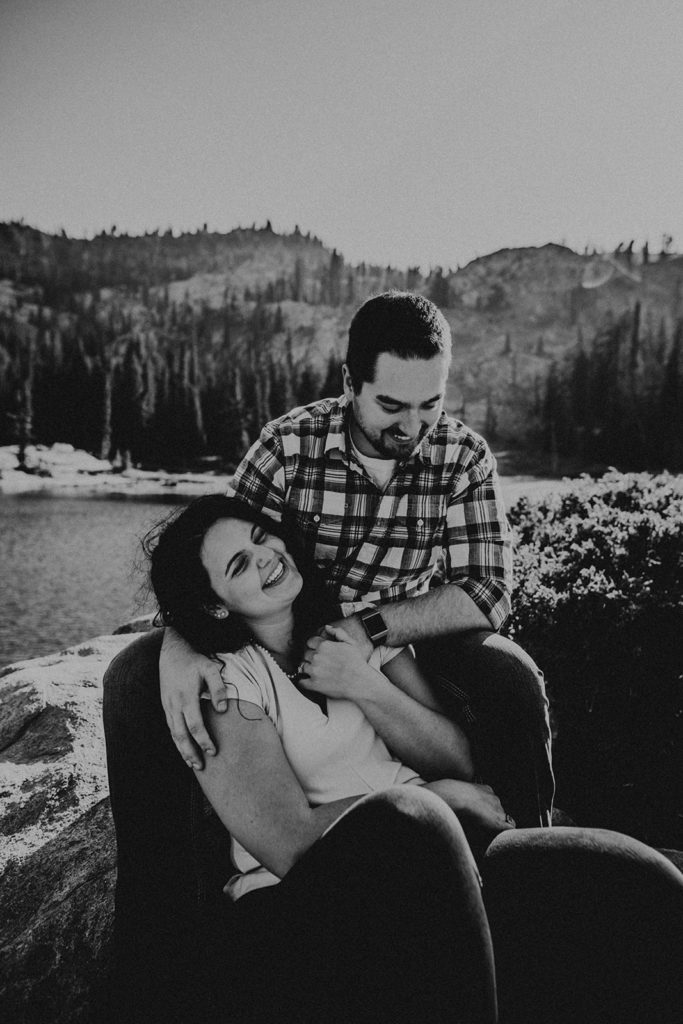 Black and white photo of couple in front of mountain lake