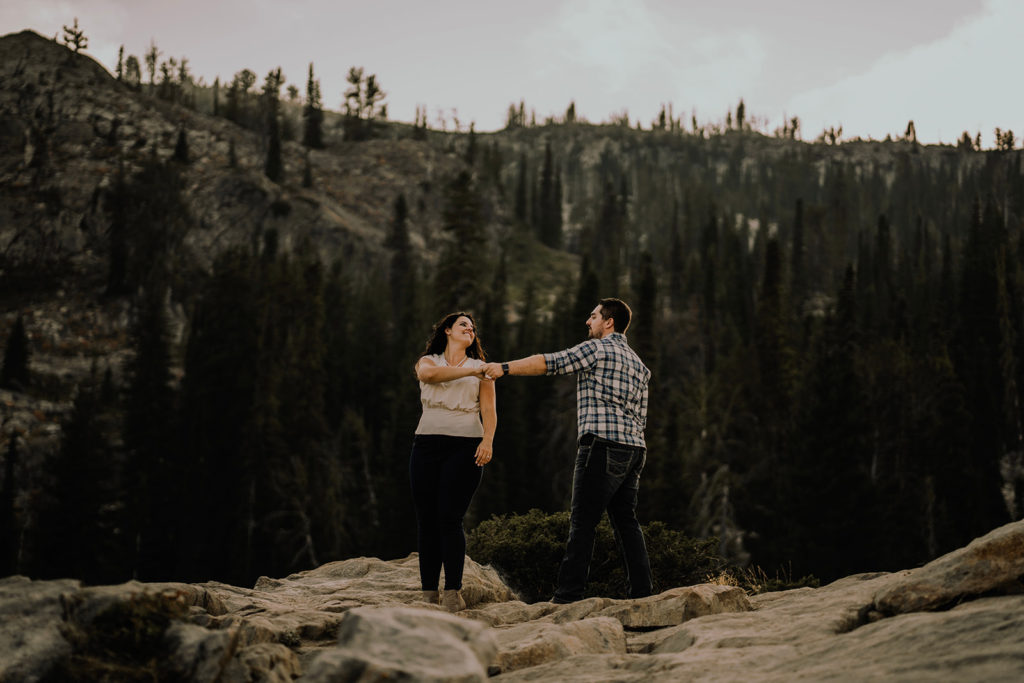 couple dances together with mountains in the background during their Blue Lake engagement session