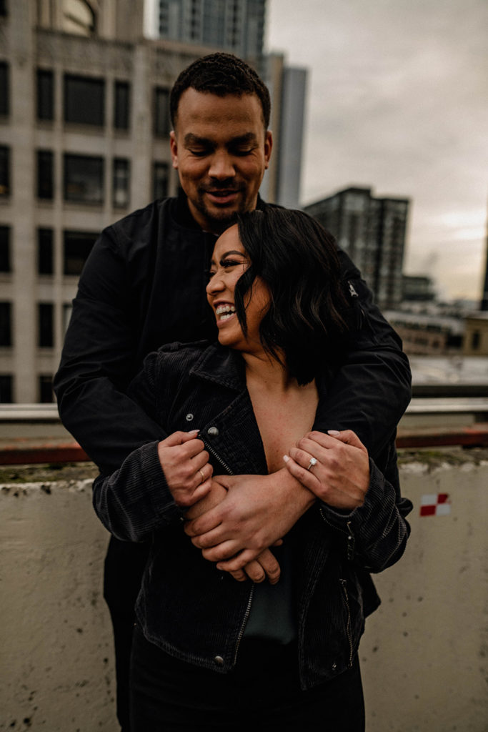 couple hugging each other on a rooftop in Downtown Seattle