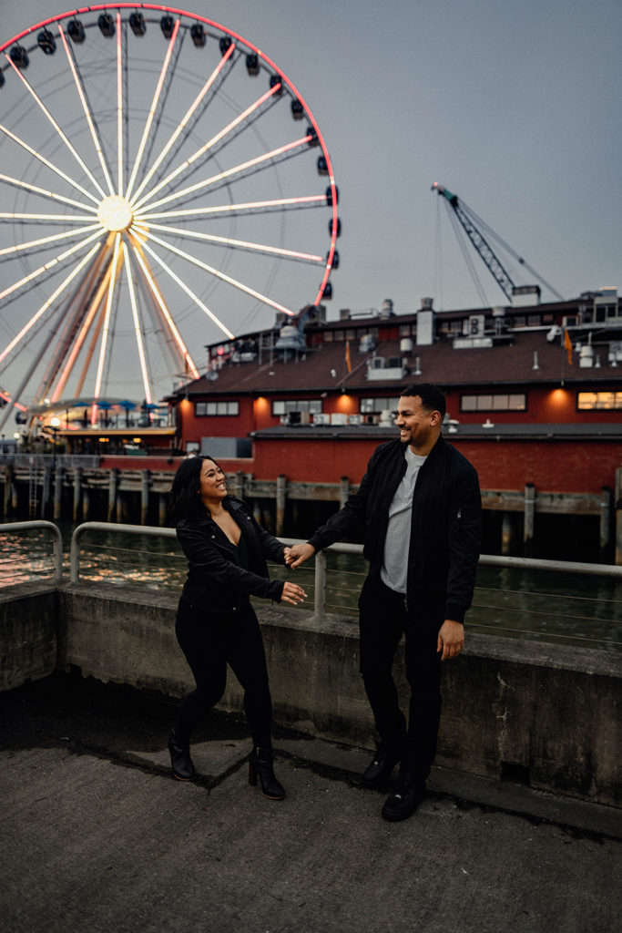 couple dances together after the sun sets on a pier in Seattle