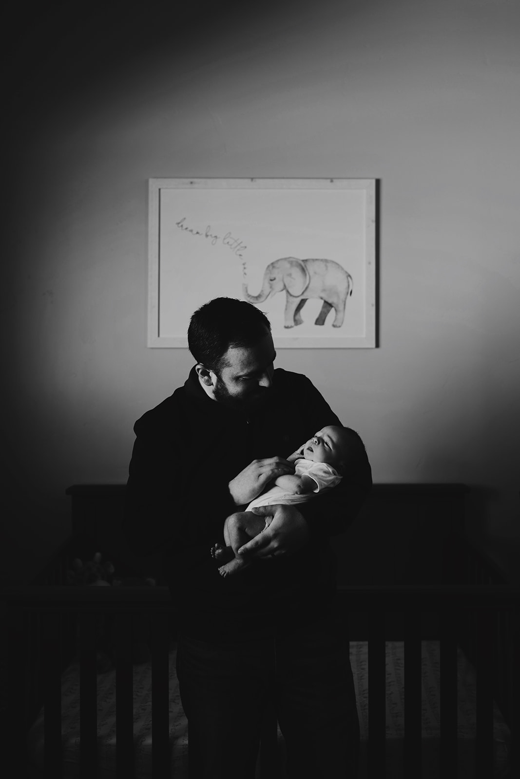 Black and White photo of a new father with his son in his nursery