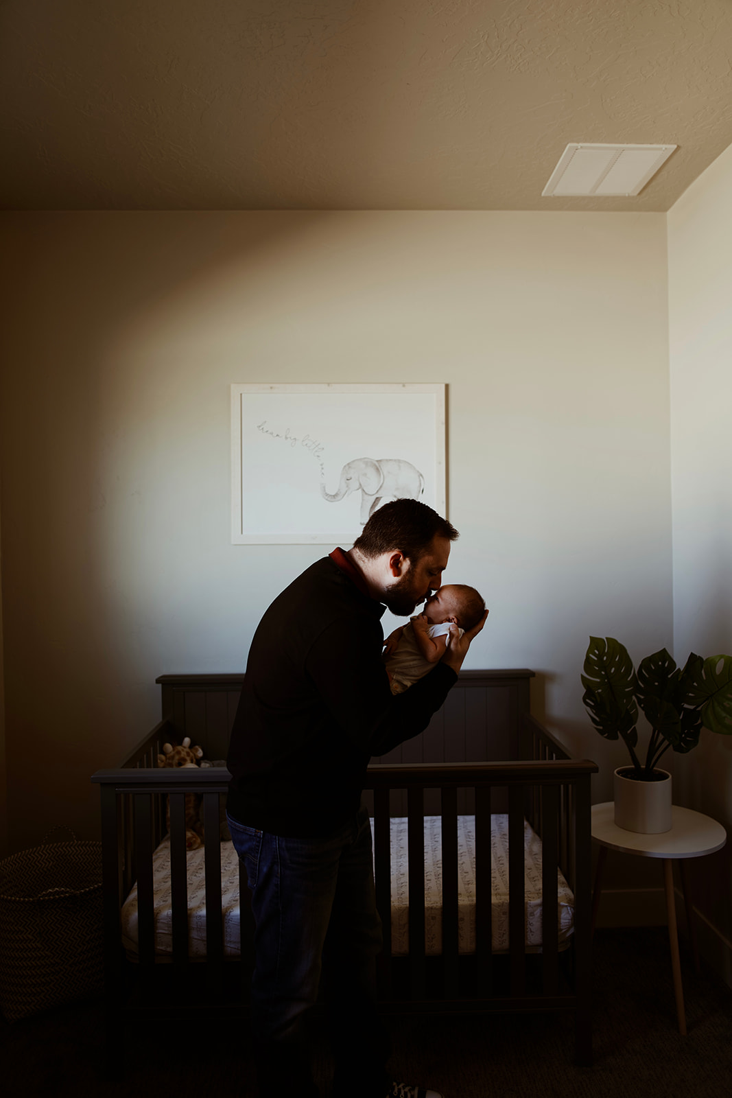 New father kisses his baby on the nose in front of his crib
