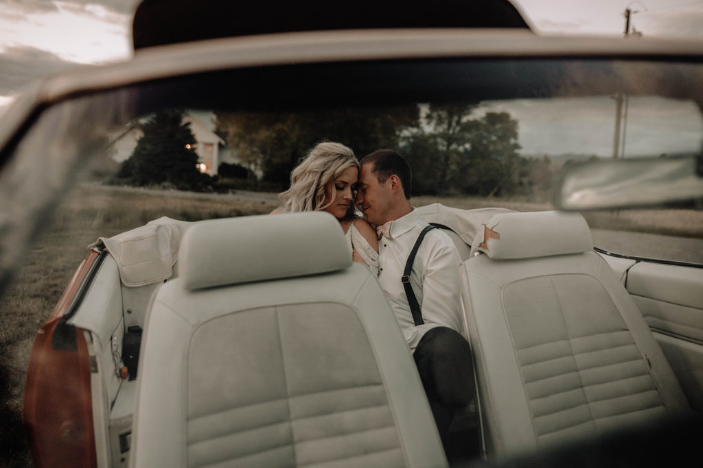 Bride and groom sit in their vintage getaway car during their Foster Creek Farm wedding