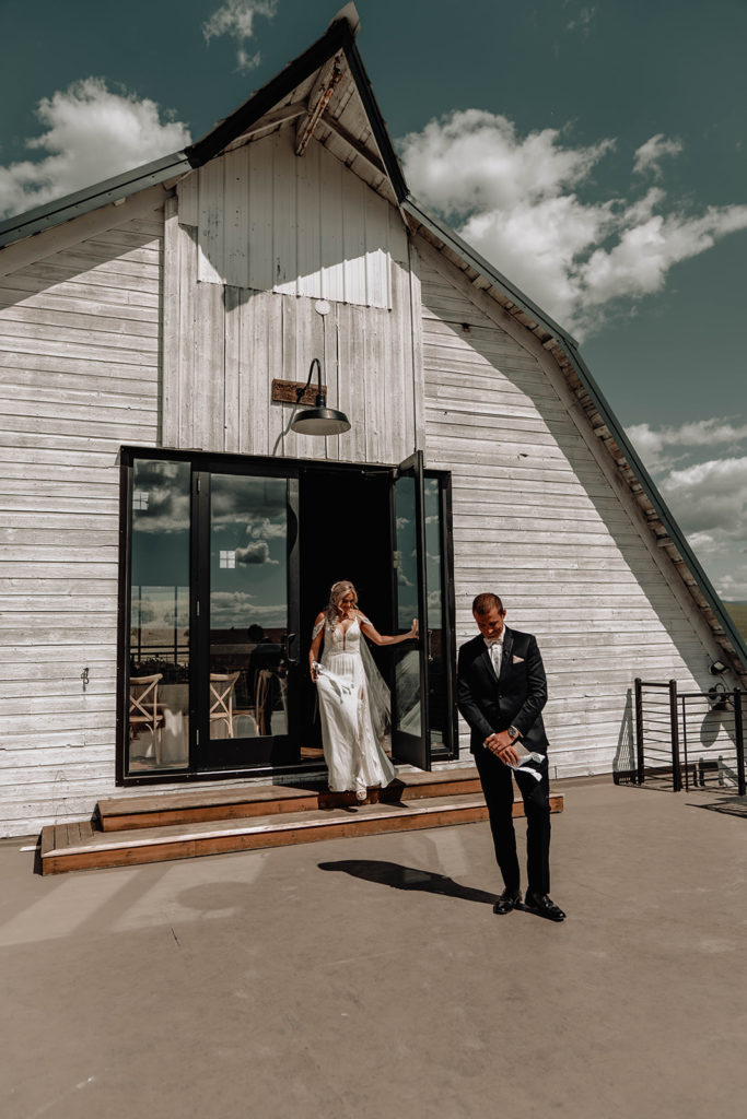 Bride walks out onto the balcony at the Foster Creek Farm barn to meet her groom for her first look