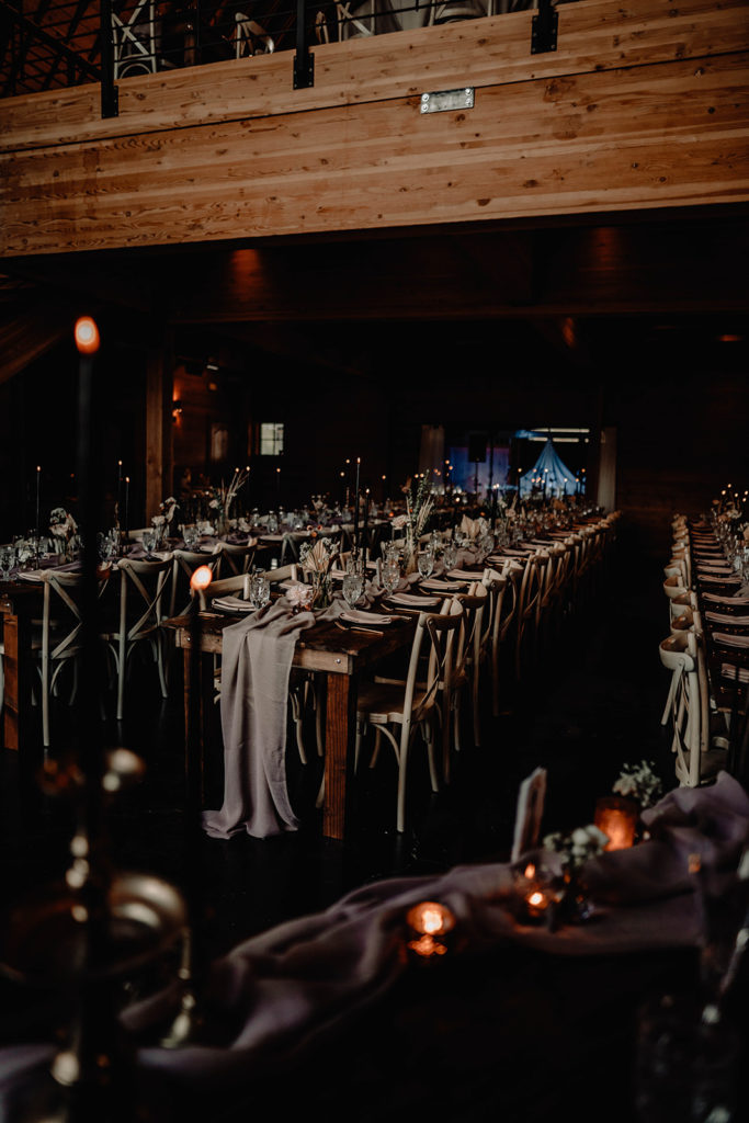 Romantic candlelit reception dinner, with black candles lighting up the elegant rustic decor
