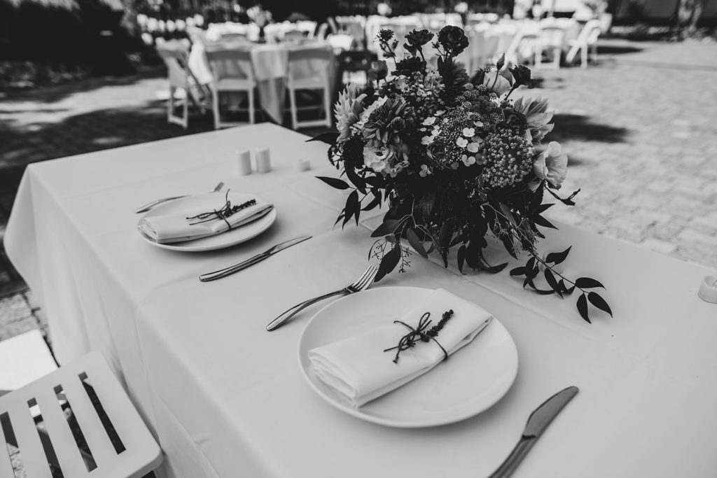 Black and white detail shot of the sweethearts table petal works design centerpiece and lavender and white place settings