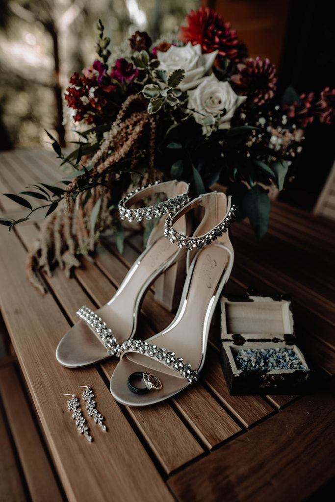 Bridal bouquet from petal works design, shoes, rings, and earrings during the Tamarack Resort wedding