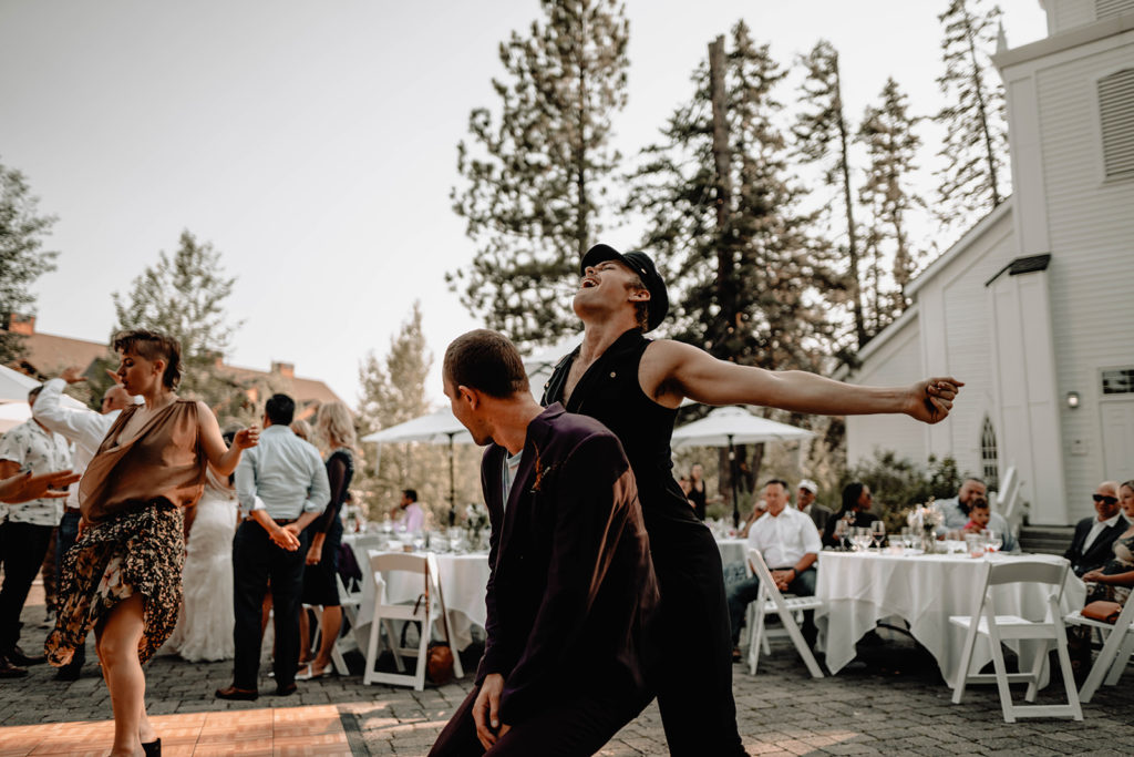 Two wedding guests have fun dancing together during the reception at the Tamarack Resort wedding