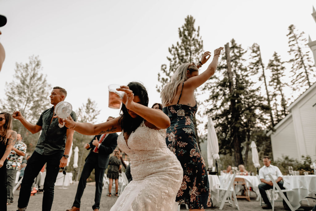 Bride and friend drop it low with drinks in hand as they dance to the music provided by Directly Driven Productions DJ