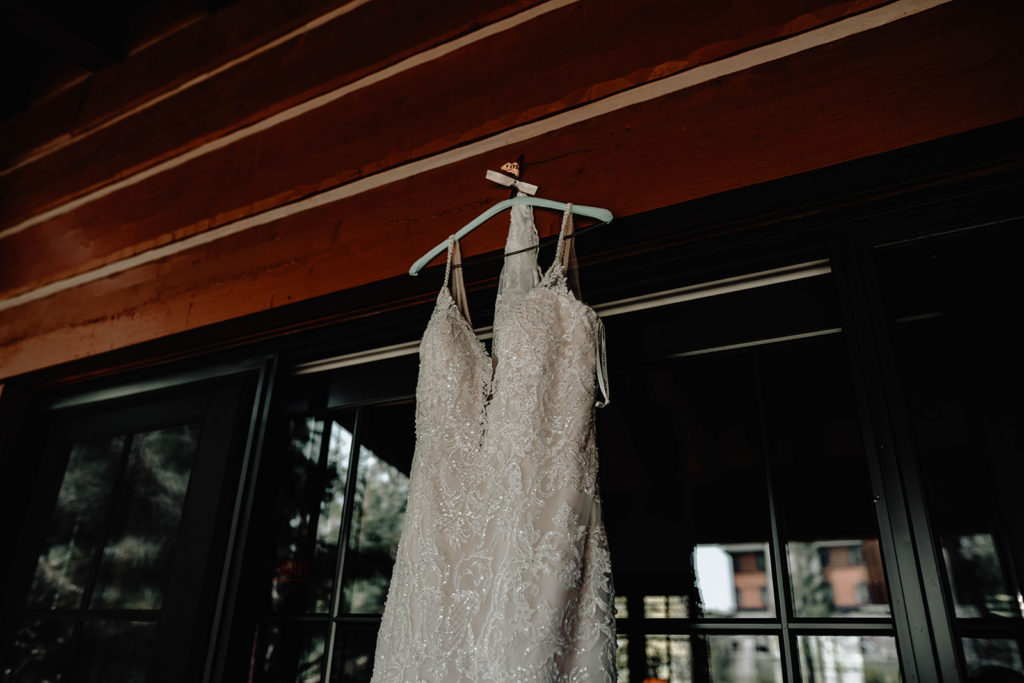 Bride's BB bridal gown hangs from a beam on the cabin patio at the Tamarack Resort wedding