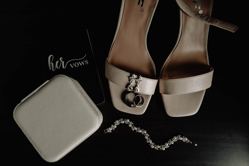 Detail shot of bride's vow book, shoes, wedding ring and jewelry before the wedding at beside bardenay
