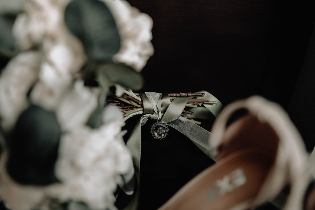 Locket memory photo attached to the bride's wedding bouquet during the wedding at beside bardenay