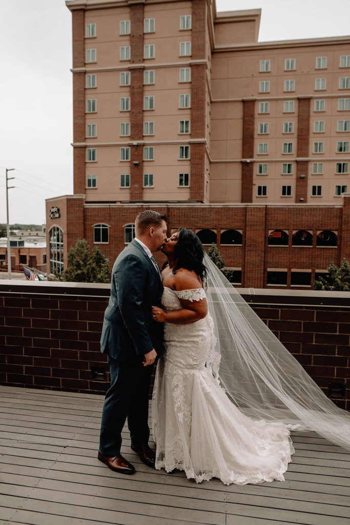 Bride and groom share a kiss on the balcony of the Residence Inn in downtown Boise as they wait for their ceremony to begin