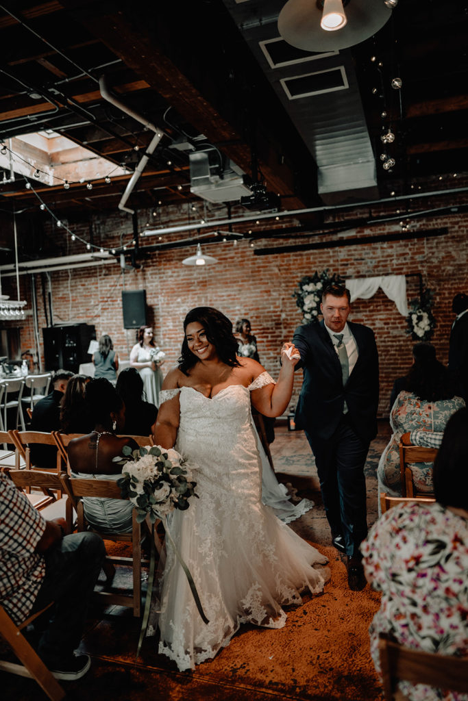 Bride leads her groom down the aisle after their beside bardenay wedding ceremony