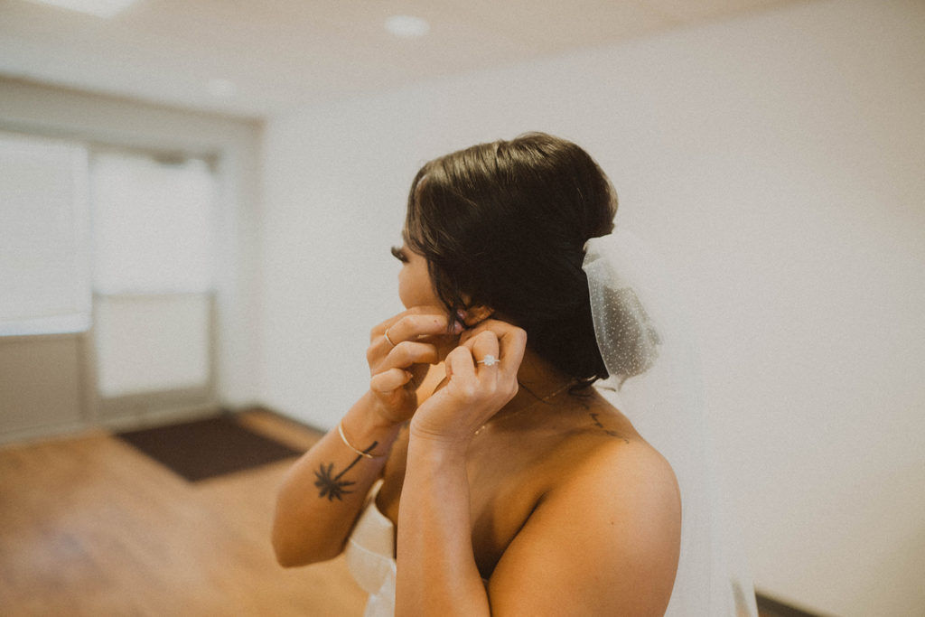 Bride adjusts her earrings before her wedding ceremony at St. Aloysius Church begins.