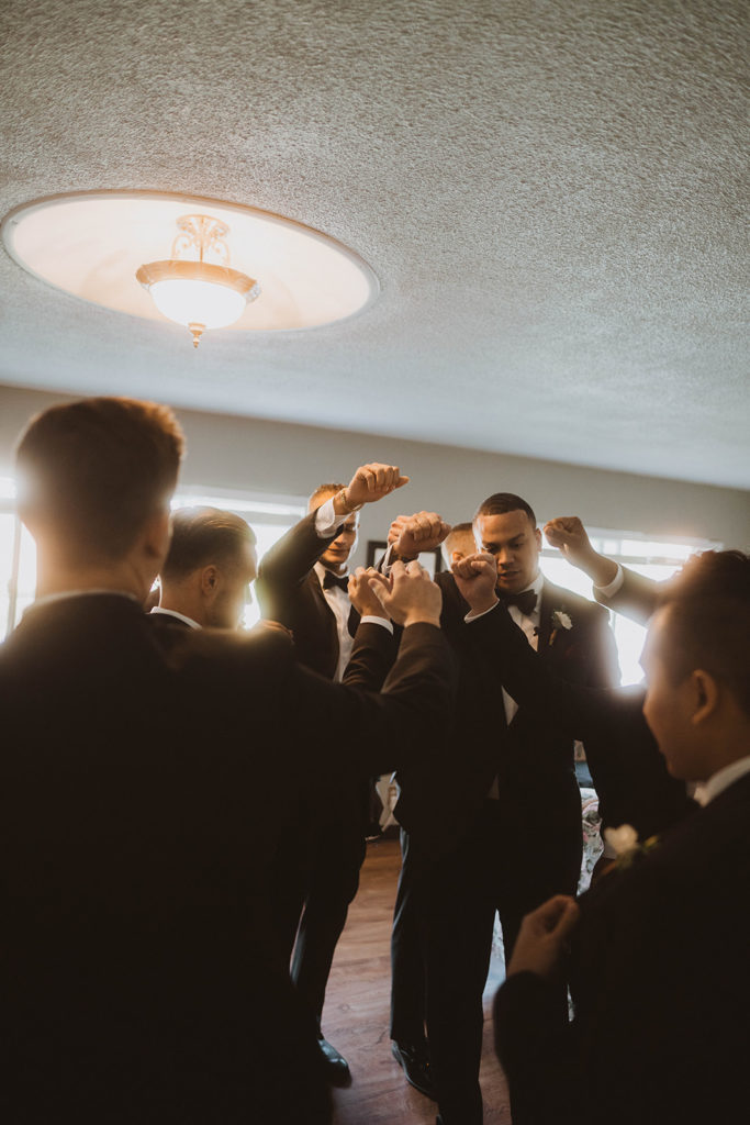 Groom and his wedding party get pumped up before the wedding ceremony begins.