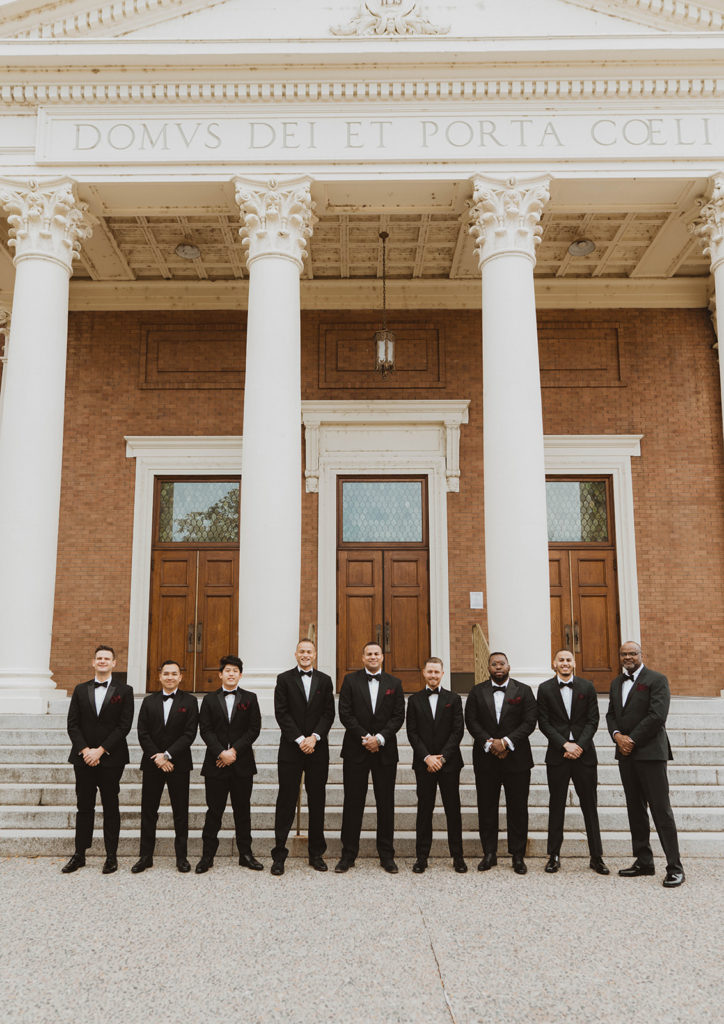 Groom and his groomsmen stand in front of the steps of St. Aloysius Church at Gonzaga University before the wedding ceremony begins.
