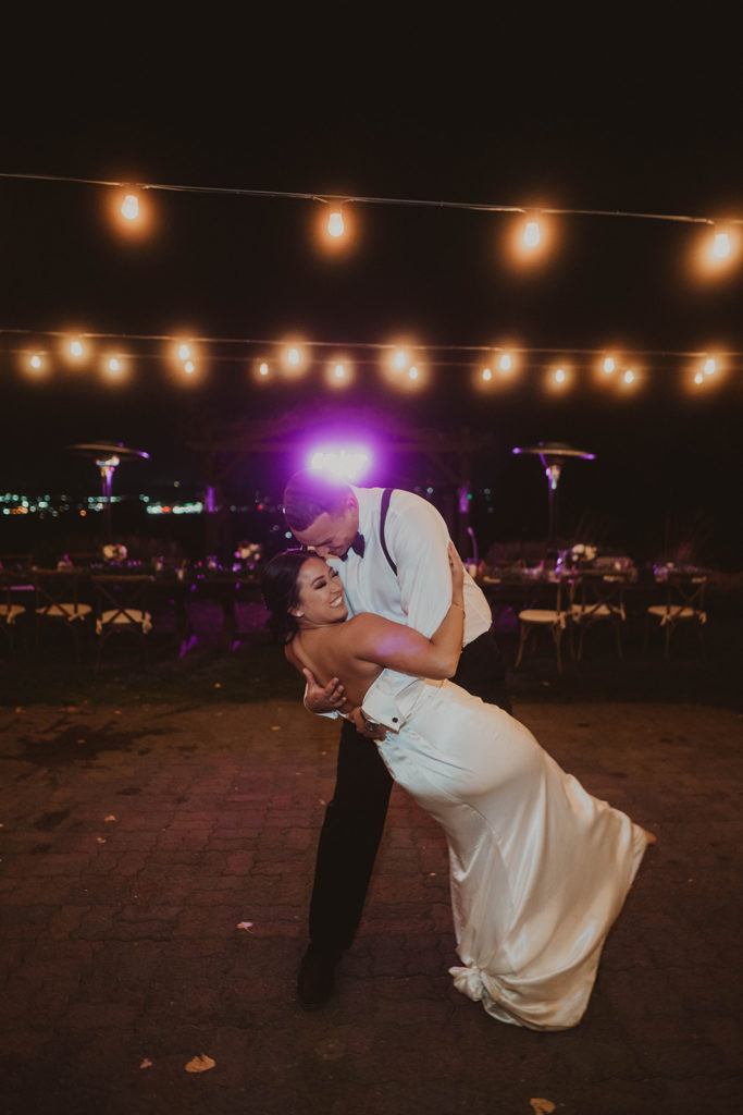 Groom dips his bride and pulls her close during their dreamy private last dance after their wedding at Beacon Hill