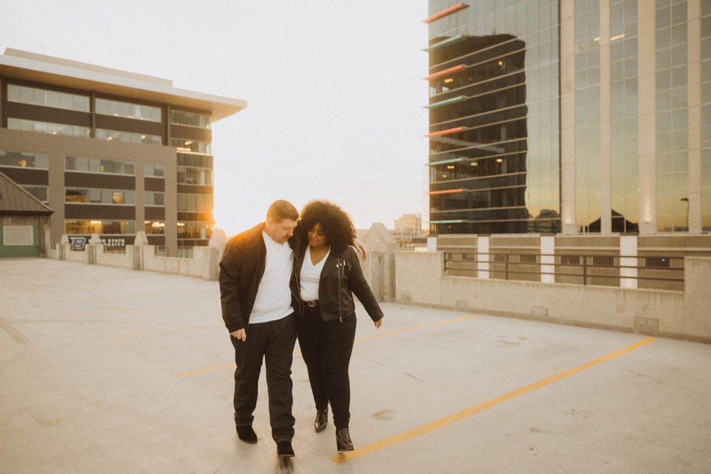 parking garage couples session, couple walks together as the sun sets