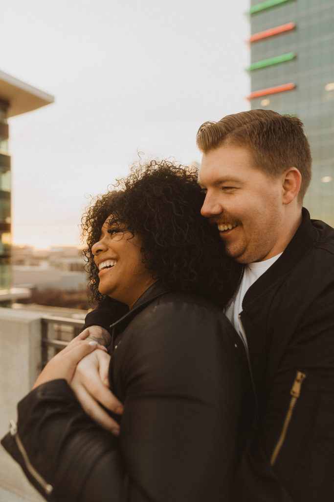 engagement film photos, couple laughs together on a parking garage