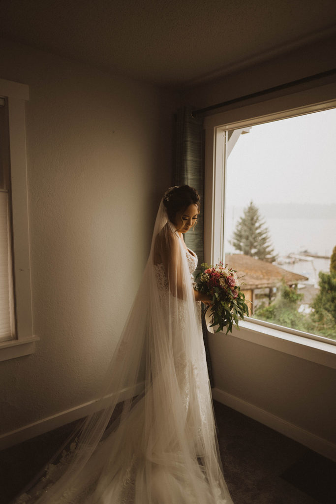 photo of a bride at the window getting ready in her airbnb for her tacoma elopement