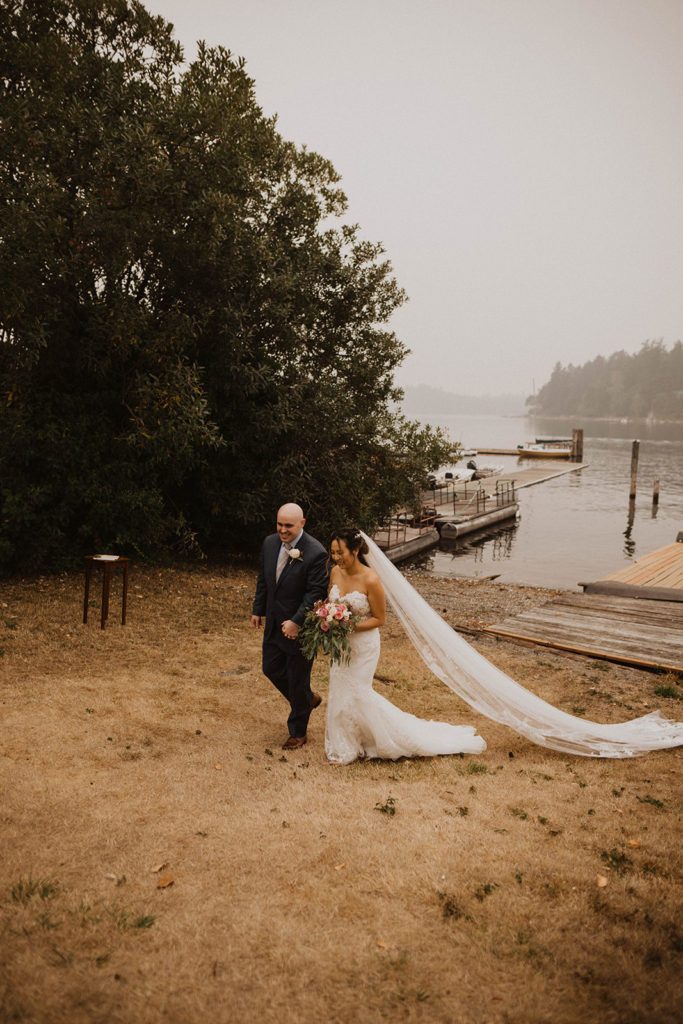 newlywed couple walks together away from American Lake