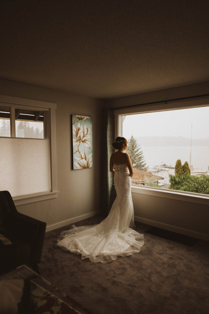 bride looking out at American lake waiting for her elopement ceremony in Tacoma to begin